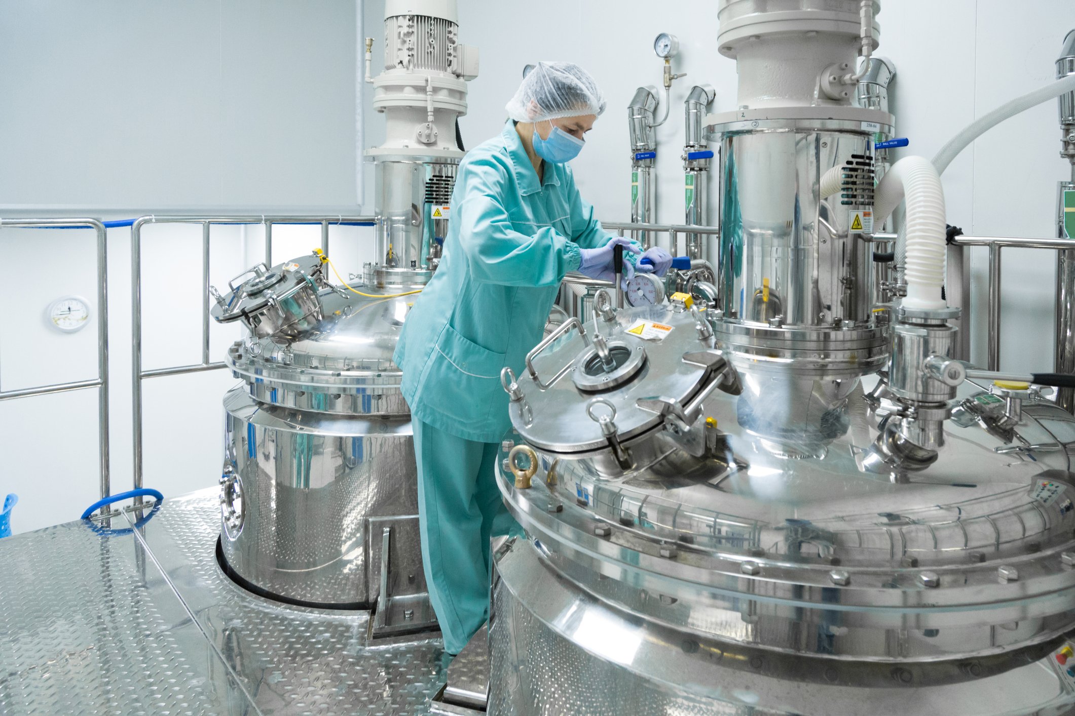 A woman works on a bioreactor for manufacturing pharmaceutical drugs.