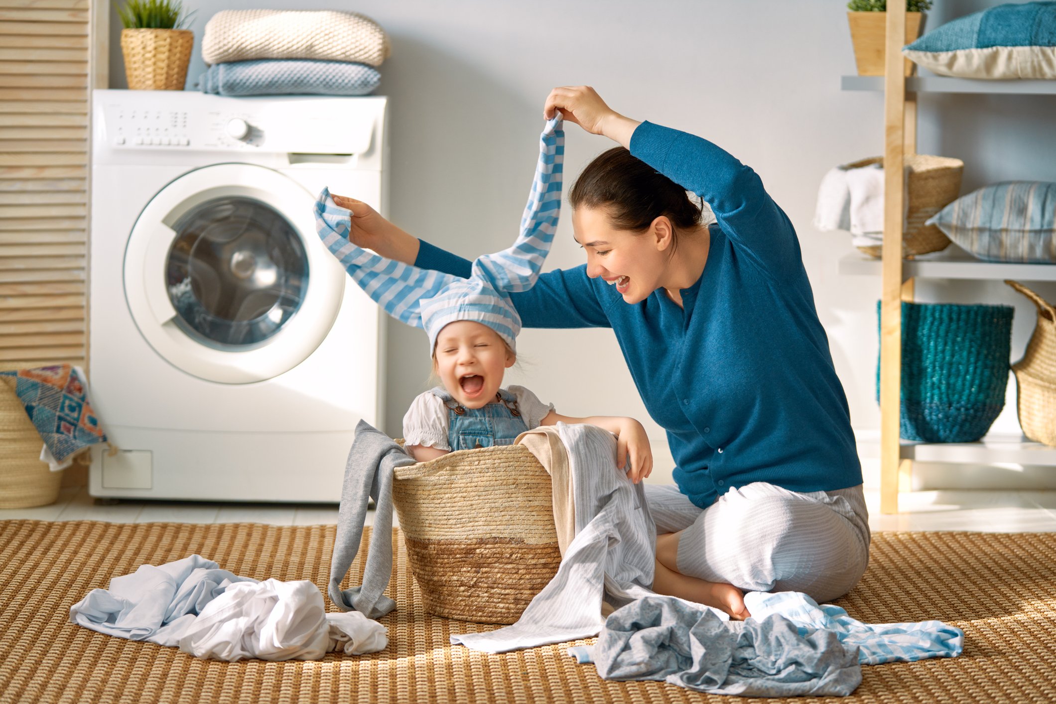 A mother and child play with laundry.