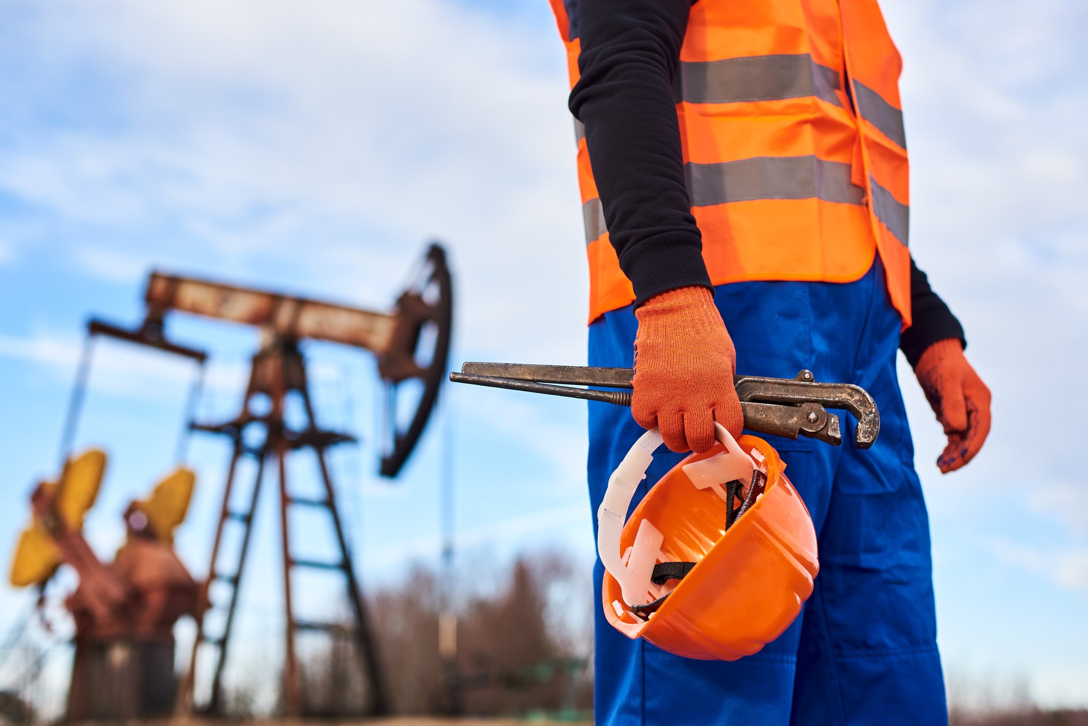 oilfield service worker standing in front of drilling wells