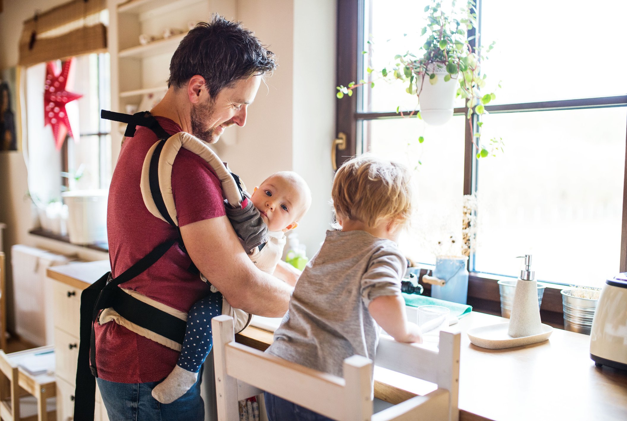 A father doing dishes with his children.