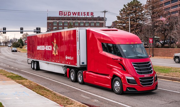 A red Nikola Two semi is shown pulling an Anheuser-Busch trailer.