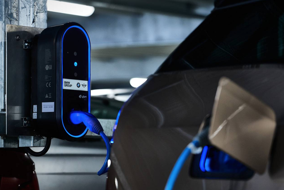 One of BMW's electric vehicles is plugged in at a charging station.