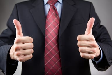 Man in suit showing two thumbs up