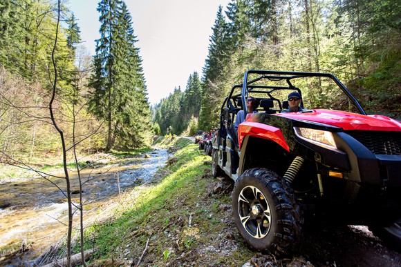 Group of ATVs riding on a wooded trail.