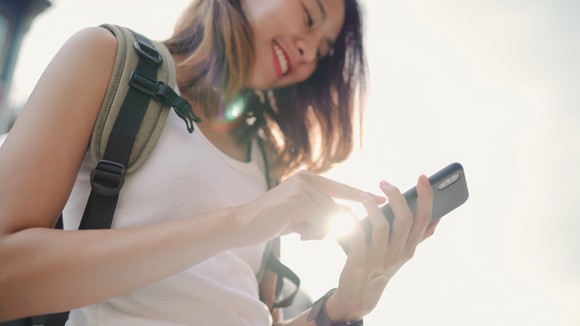 A young woman uses a smartphone.