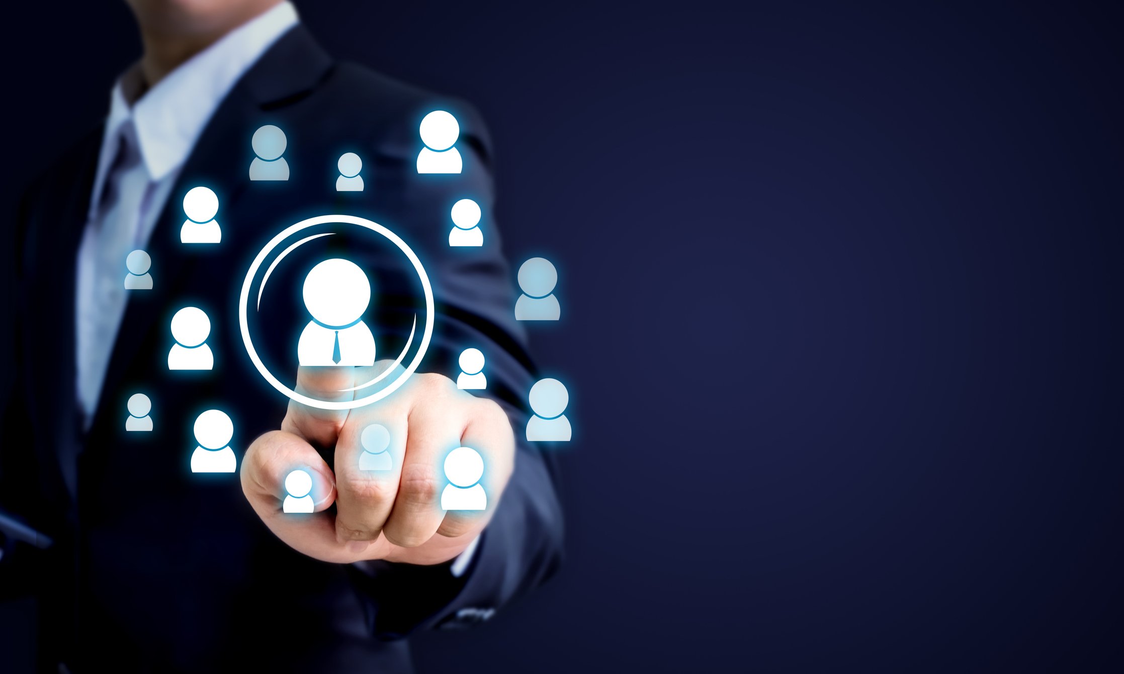 A businessman presses one icon in a cloud of human icons.