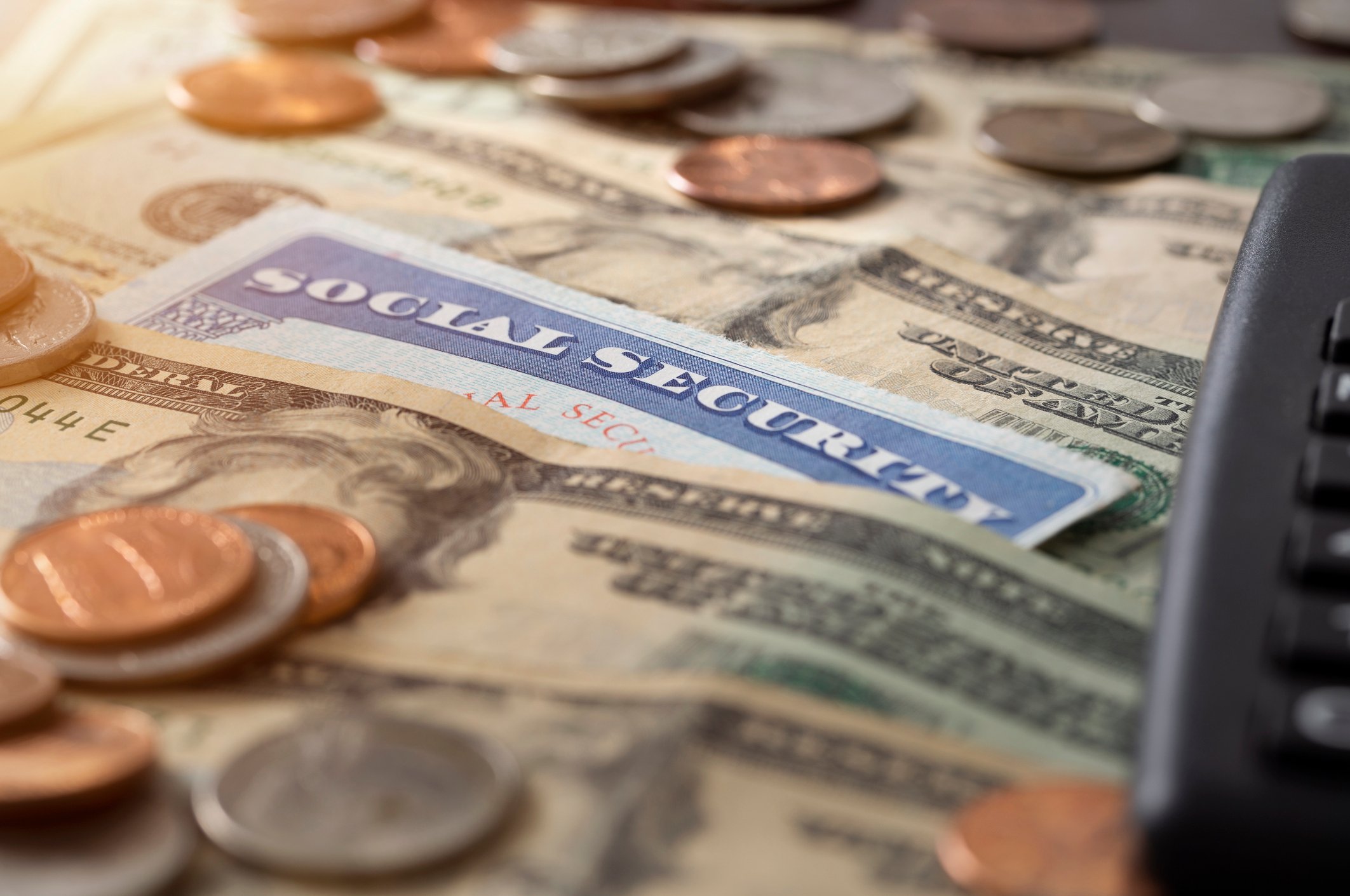 Social Security card with dollar bills and coins