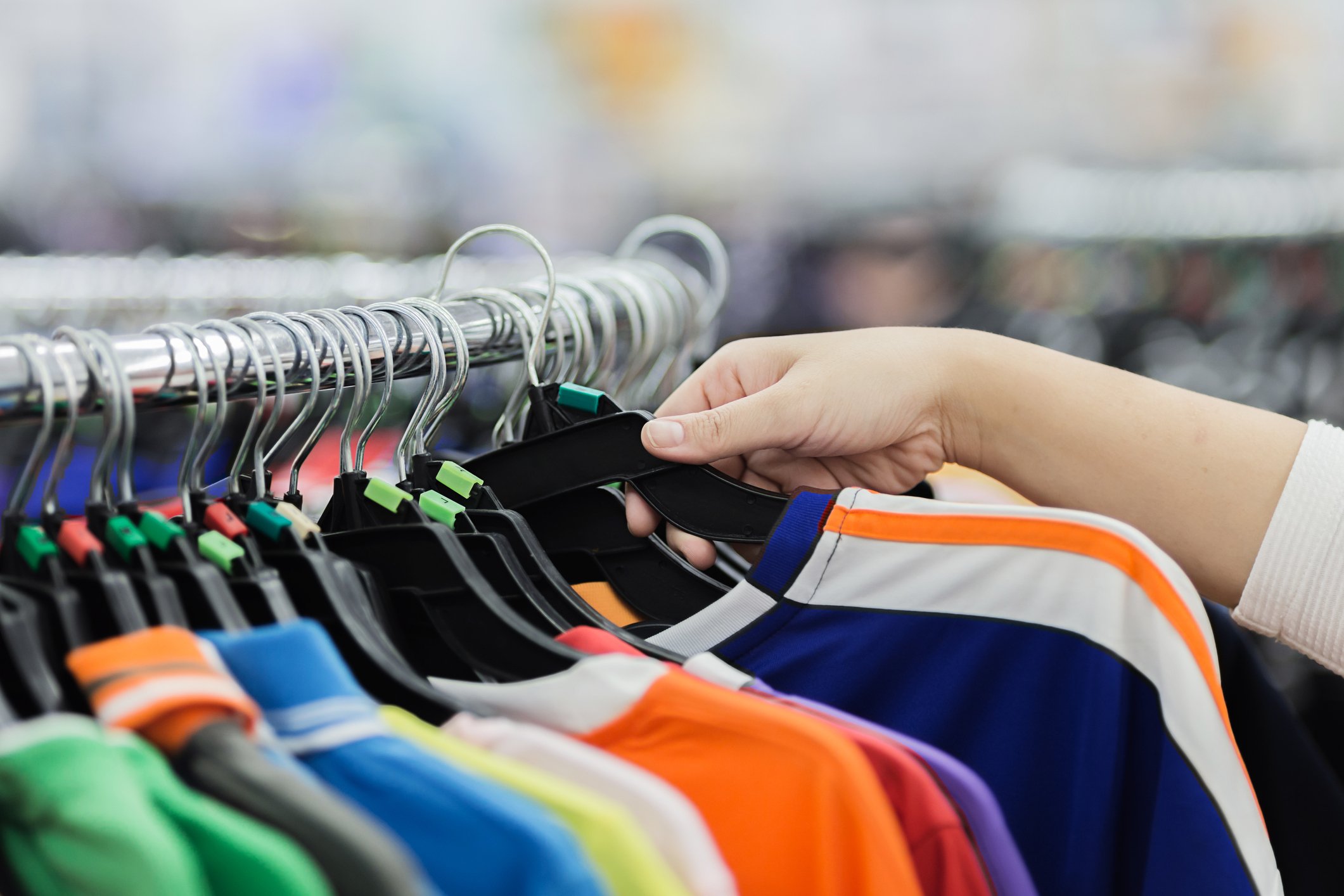 A shopper checking  out Activewear shirts. 
