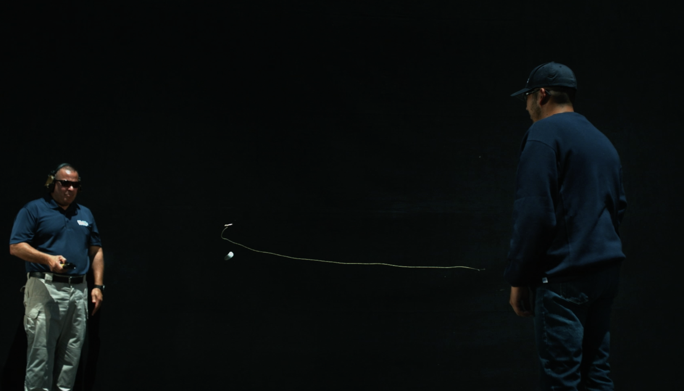 A tether flies through the air after being shot out from a BolaWrap by Wrap Technologies.