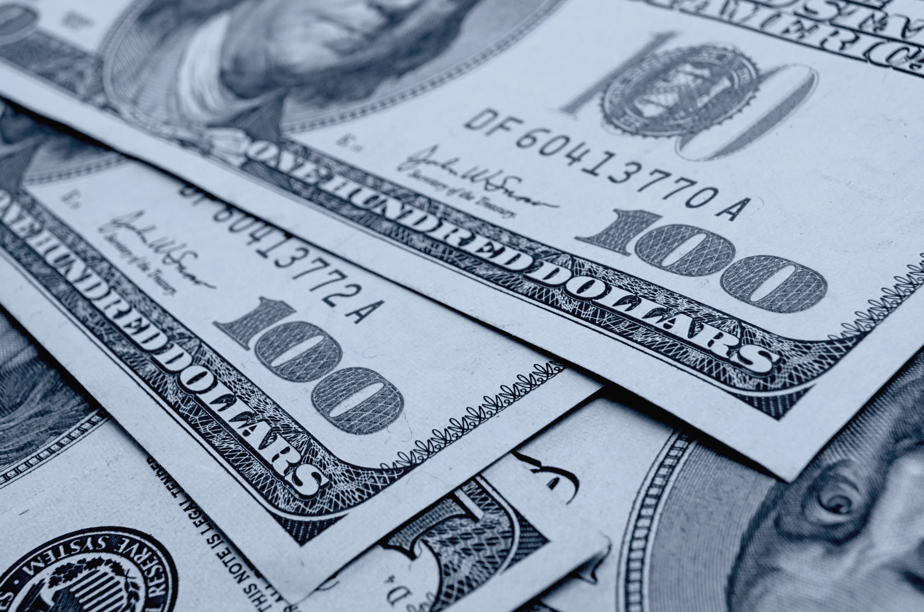 Many 100 dollar bills laid out.