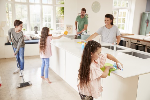 family cleaning floor and counters together in kitchen