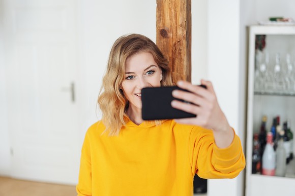 A woman recording herself with a smartphone.