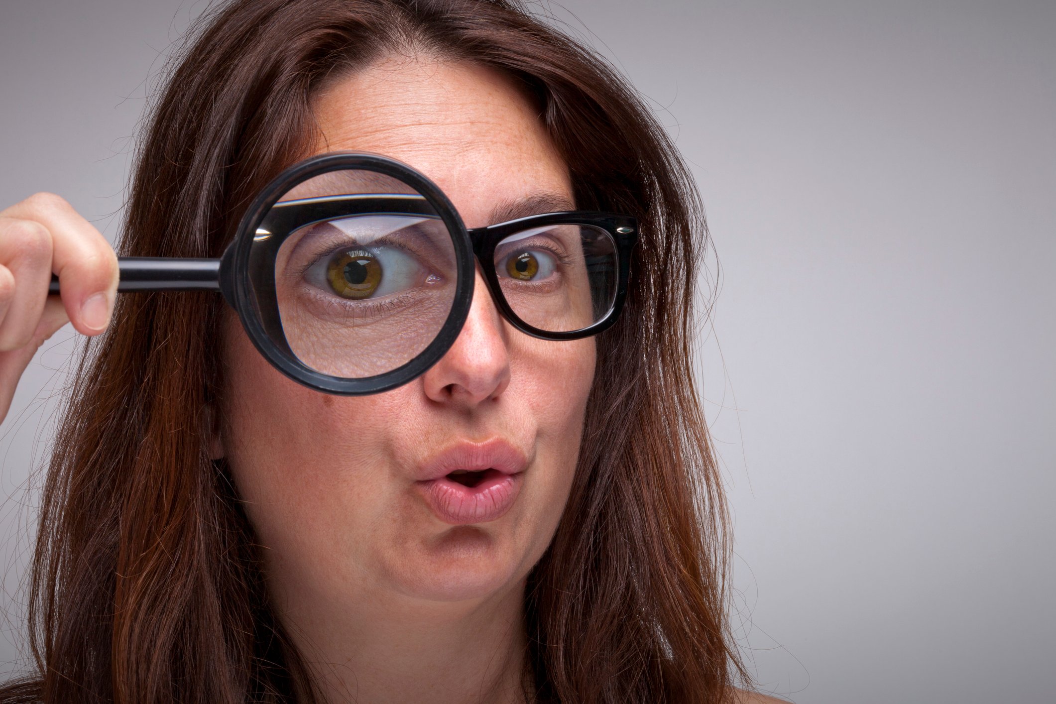 Woman looking through a magnifying glass