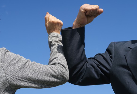 Two people bumping elbows