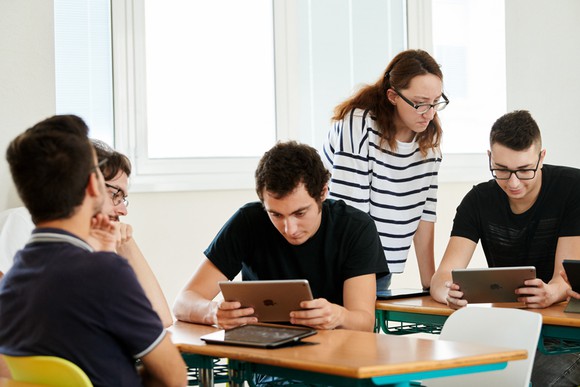 College students using iPads in a classroom. 