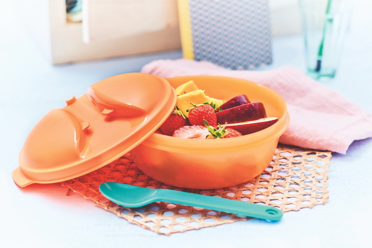 A plastic Tupperware container filled with fresh fruit