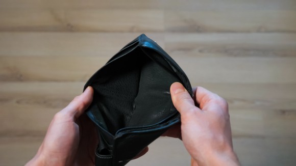 A pair of hands holding open an empty wallet.