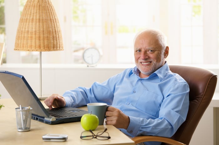 Smiling older man at laptop