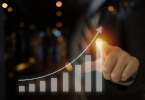 A person touching an ascending bar chart.