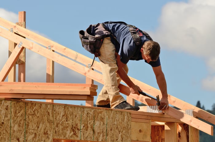 Carpenter installing roof trusses