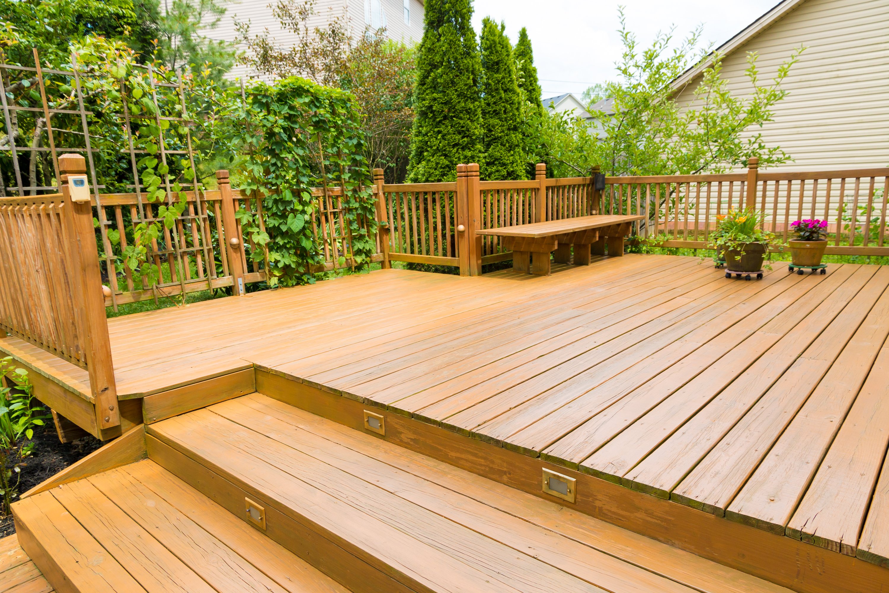 Large outdoor home deck with landscaped trees in the background