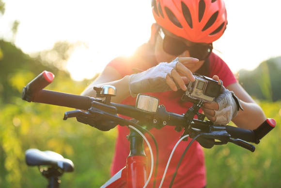 bicyclist looking at action camera mounted on handle bars