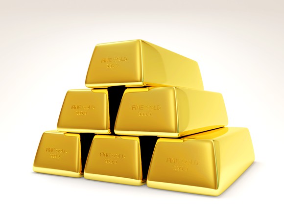 Six bars of gold bullion stacked in a pyramid.