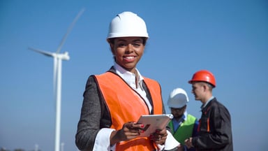 Woman of color in hardhat on wind farm