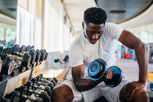 A man lifting weights in a gym. 