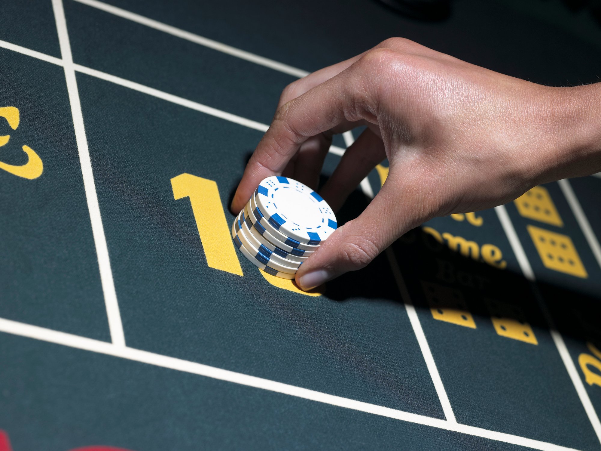 Hand placing chips on a gaming table. 