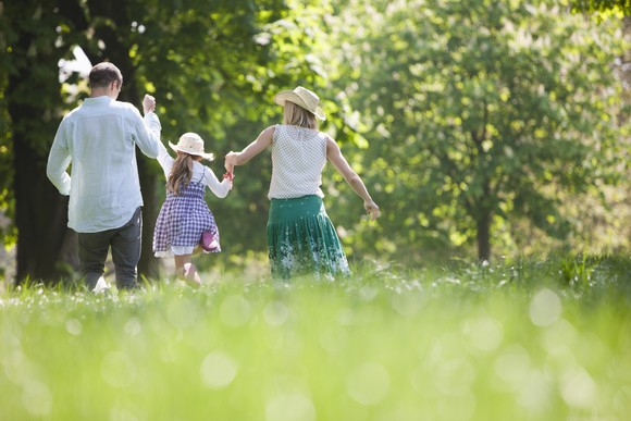 Family walking through a field holding hands