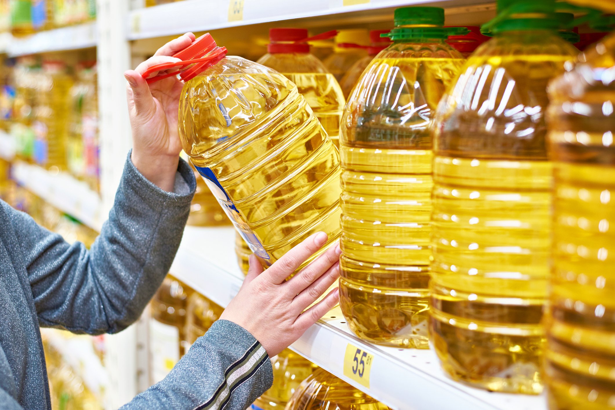 Customer grabbing a bulk-size container of cooking oil.