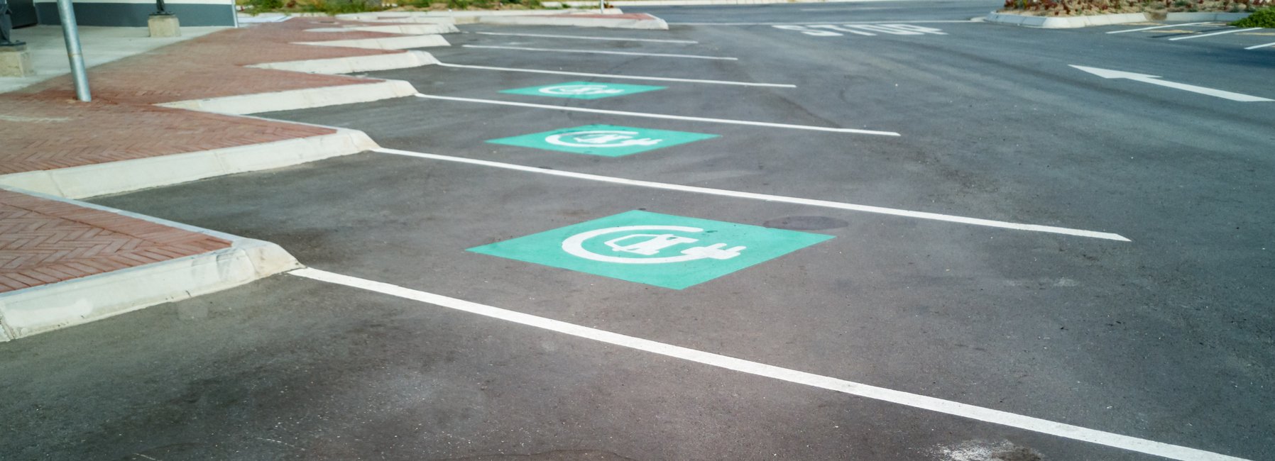 A row of clearly marked but empty car-charging parking spots.