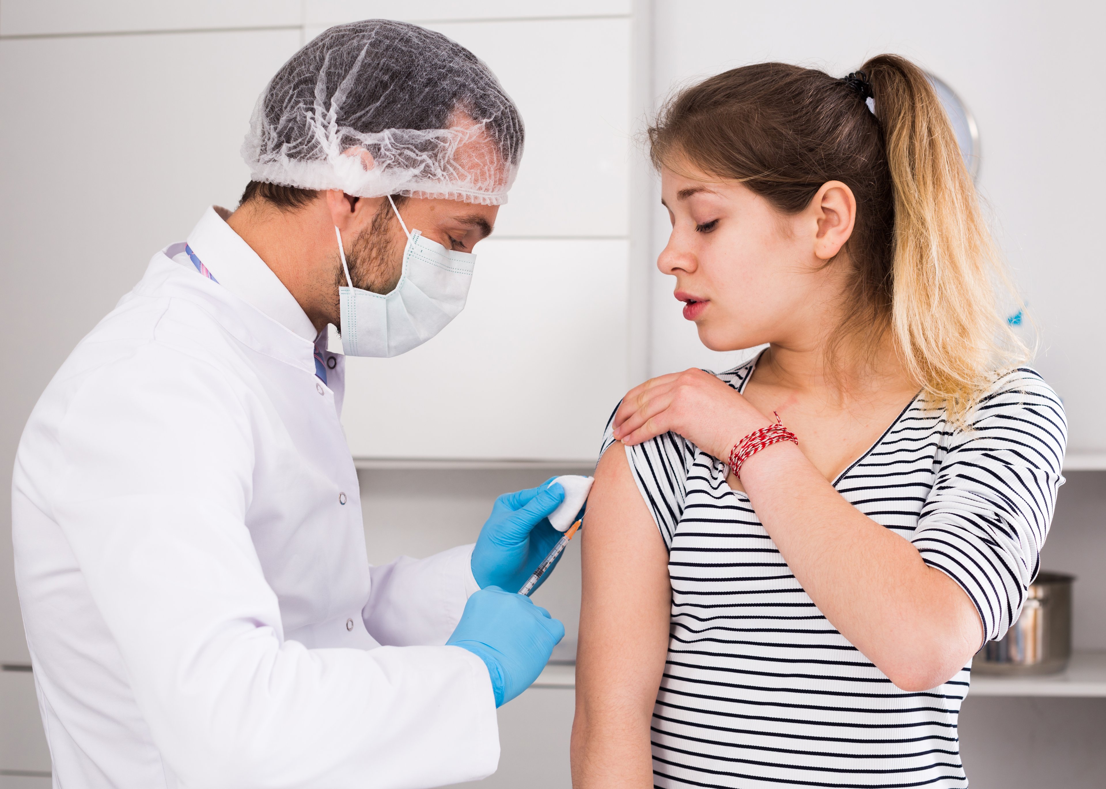 Doctor giving patient vaccine in a clinic. 