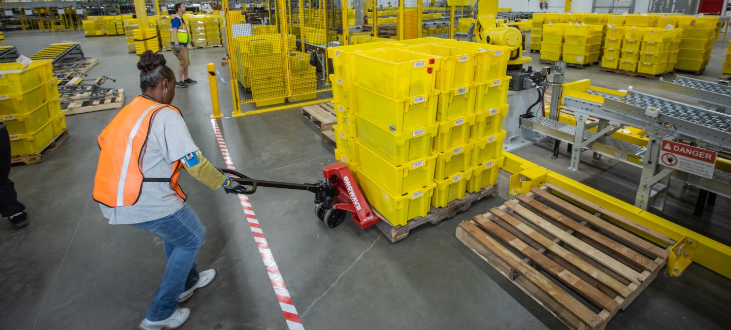 Amazon.com employee pulling crates at warehouse