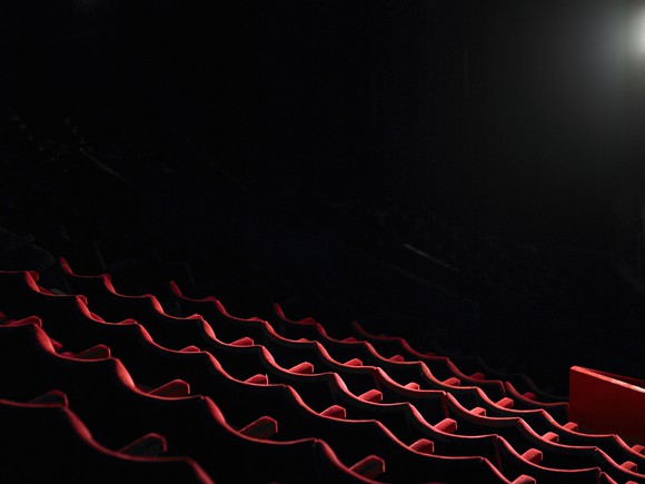 Photo of empty seats in a dark movie theater.