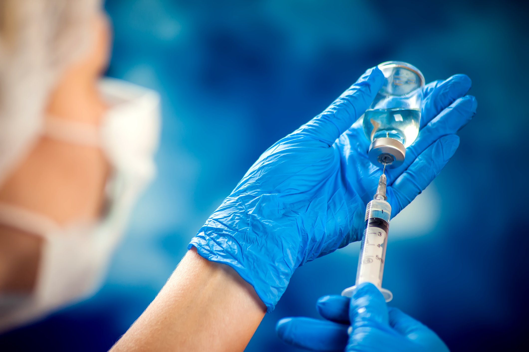 Scientist holding syringe and vaccine bottle