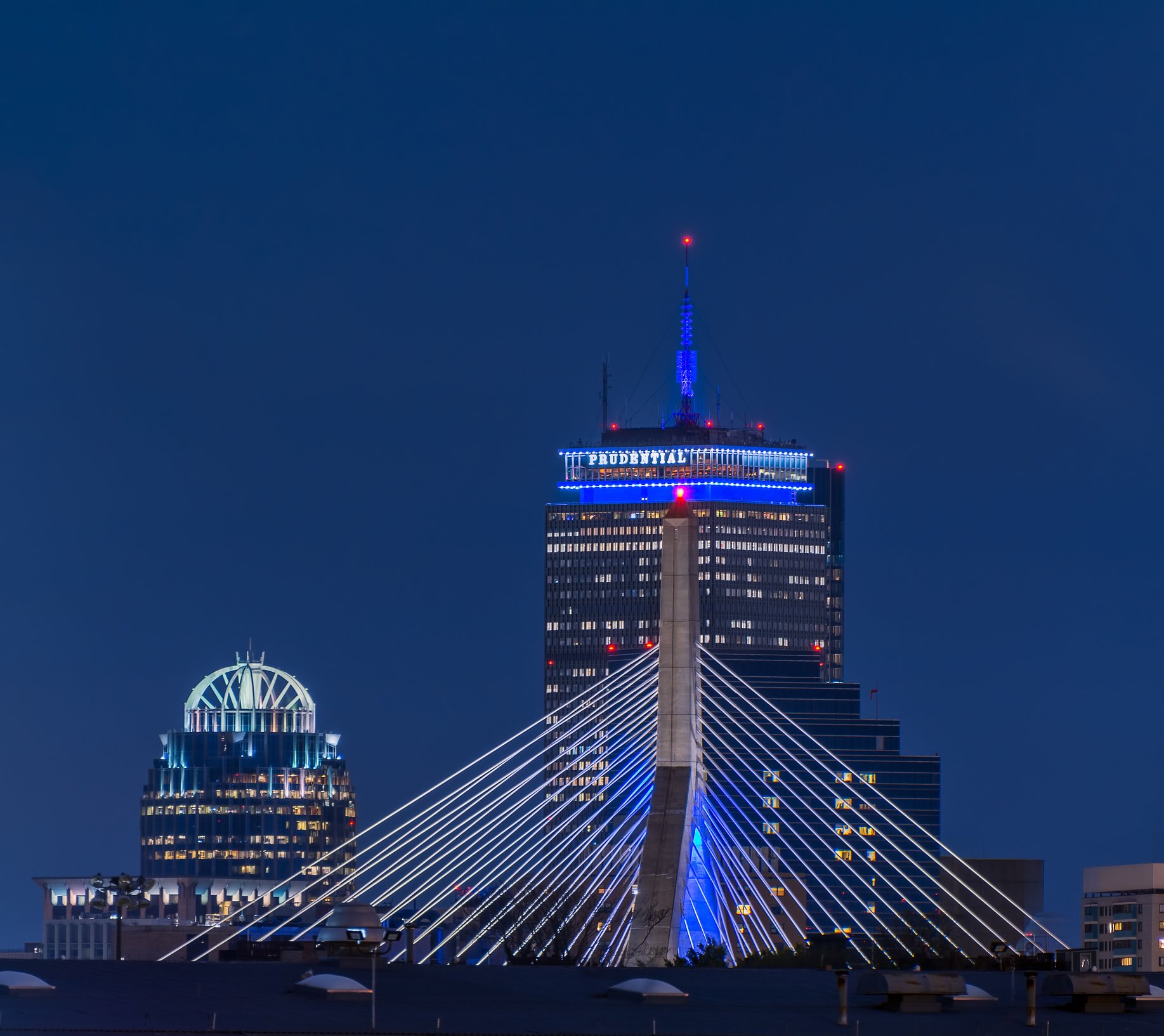 The Prudential Building in Boston at night, with the Zakim Bridge in the foreground. 