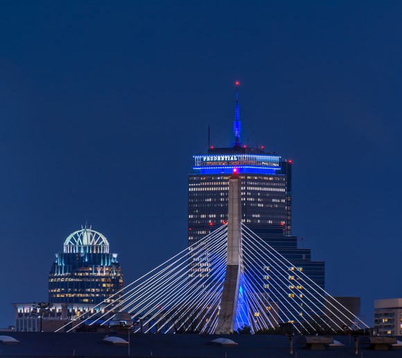 The Prudential Building in Boston at night, with the Zakim Bridge in the foreground. 