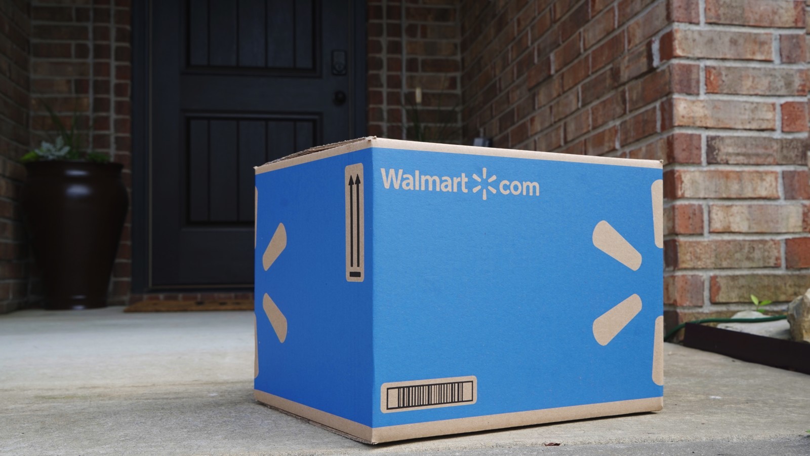 A blue Walmart shipment box sitting in front of a house.