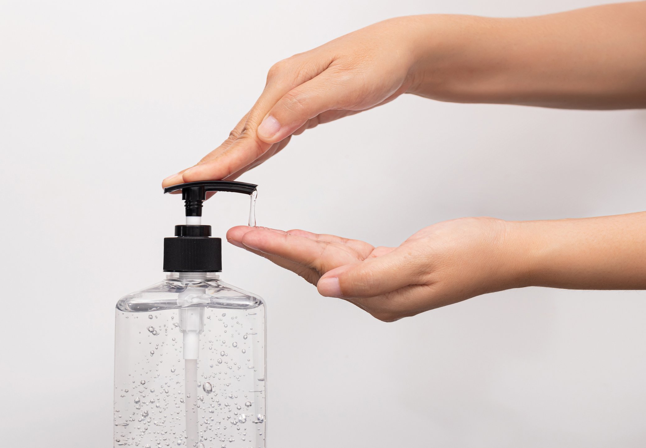 Woman dispenses hand sanitizer from a bottle.