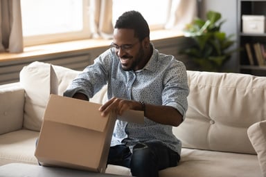 Smiling person of color opens ecommerce package