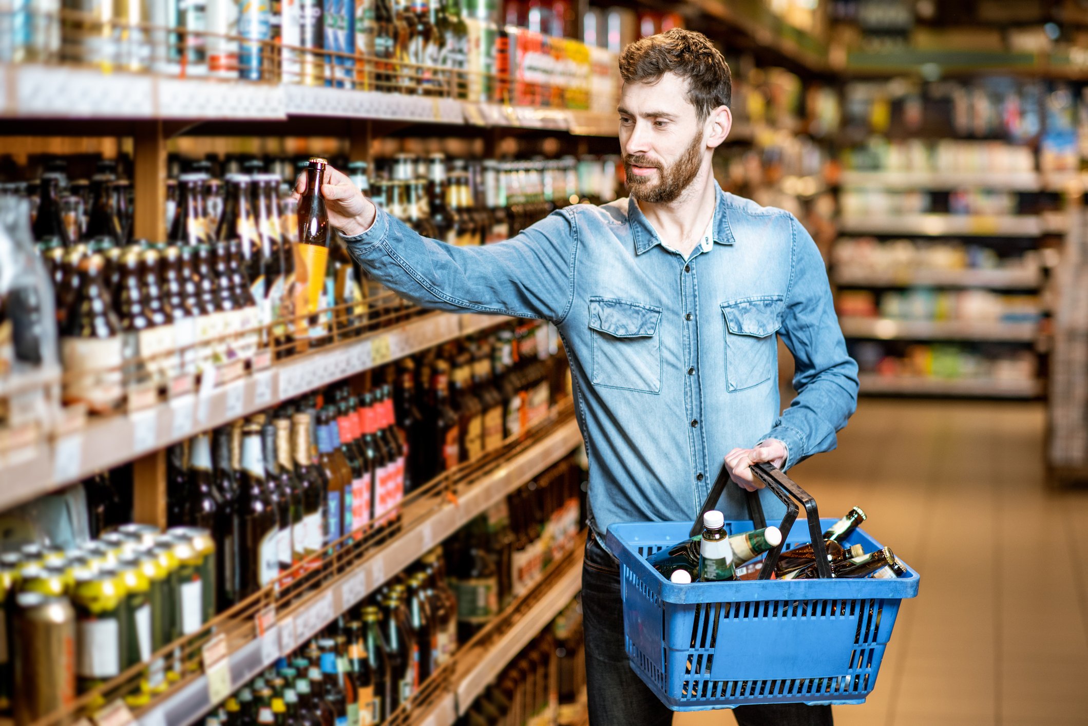 A man shops for beer at a grocery store.