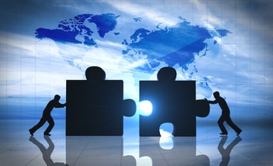 2 men pushing giant jigsaw pieces together