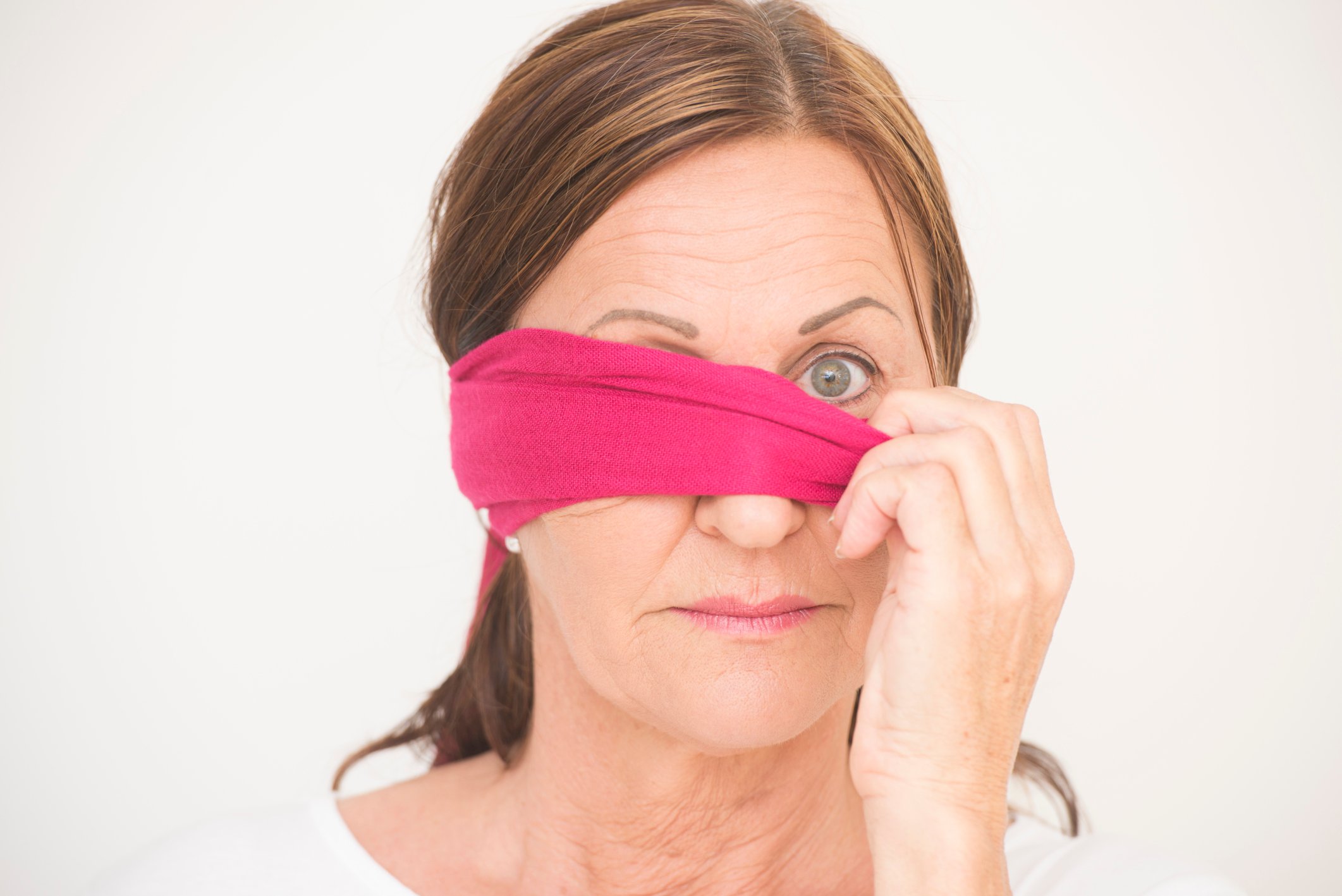 Mature woman taking off pink blindfold