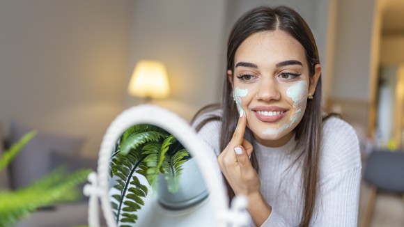 Woman applying face cream.