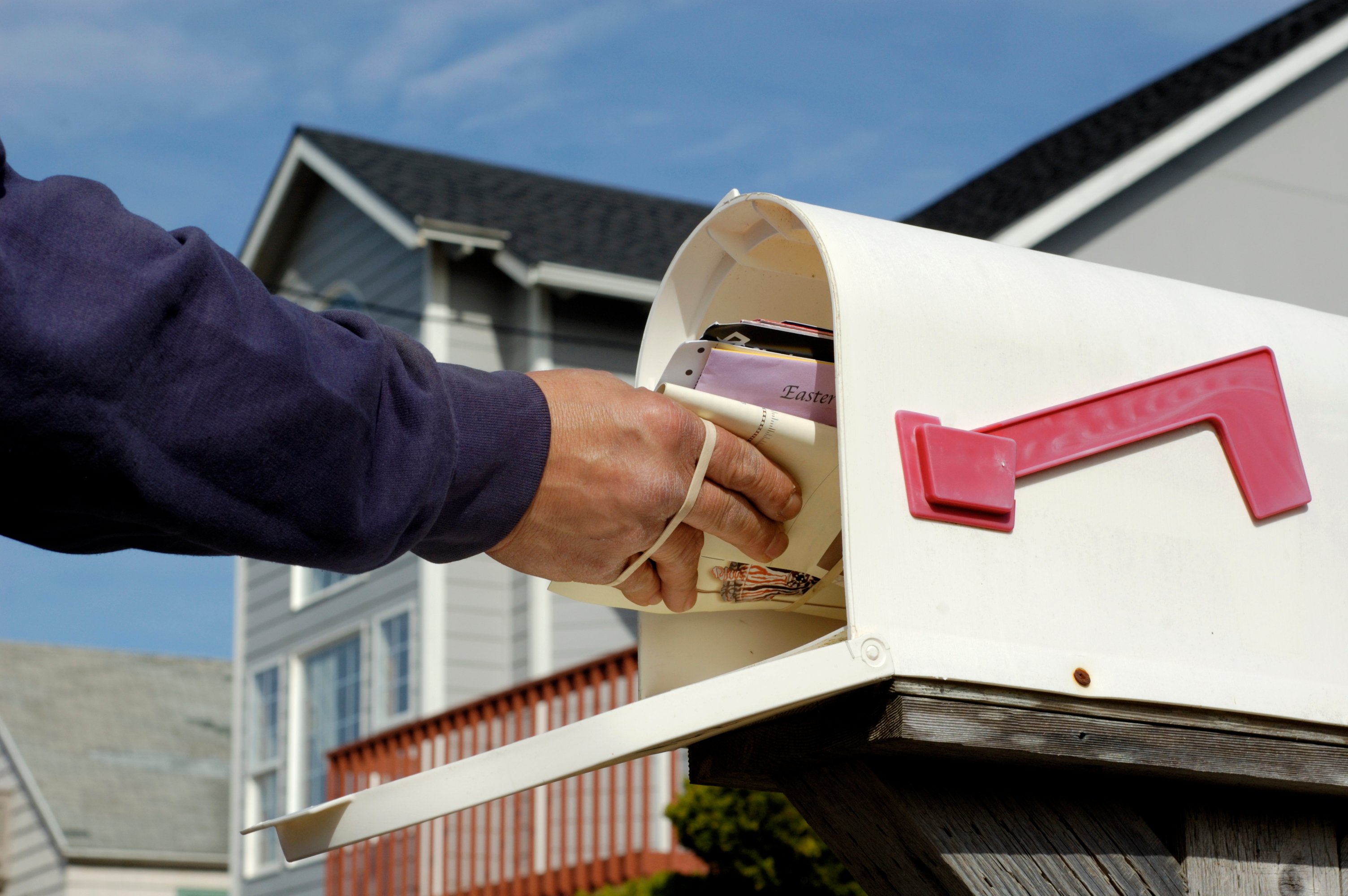 Mail being delivered to a mailbox.
