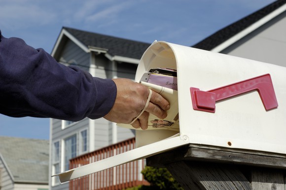 Mail being delivered to a mailbox.