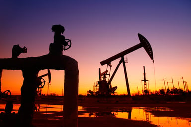 A pipeline and an oil pump at sunset.