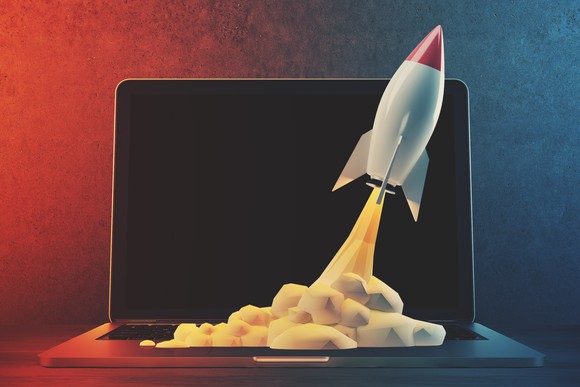 A computer rendering of a rocket taking off from a laptop keyboard.
